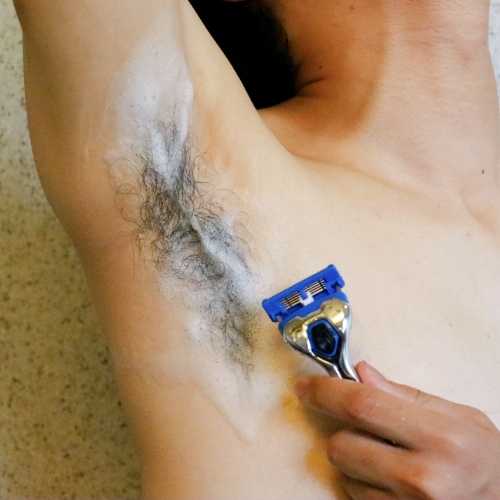 man shaving his armpits