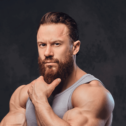 Muscular man with ginger hair and long beard possing after using beard butter